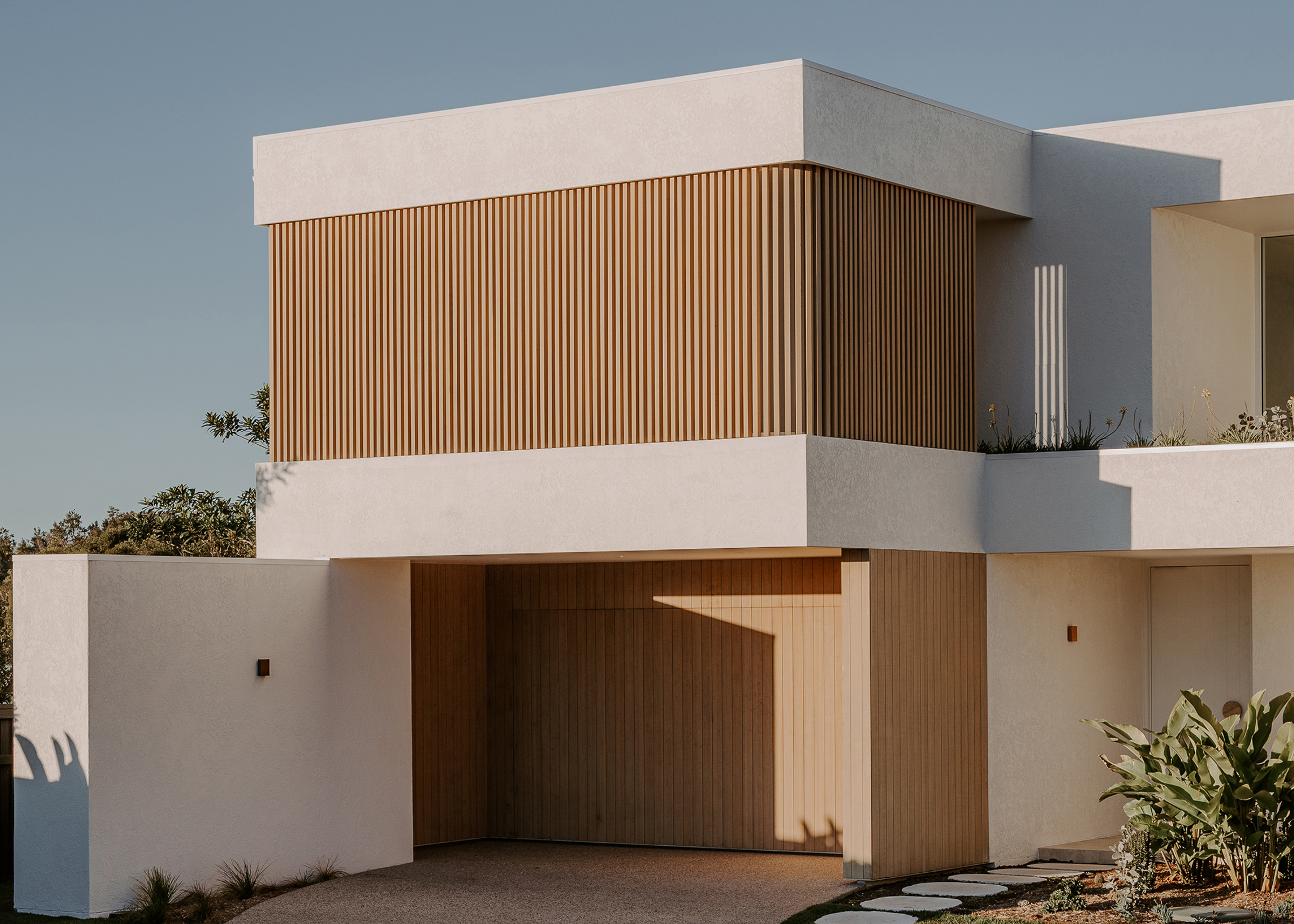 Harvest Moon Byron Bay exterior street view showing white render and timber battens