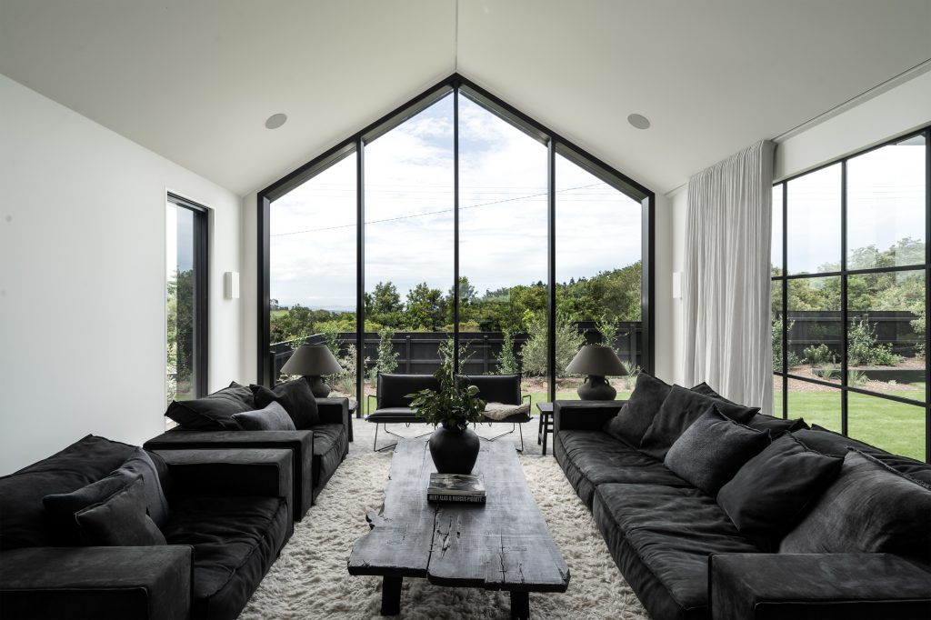 Nox Byron Bay living room with high pitched roofline, white walls and black furniture