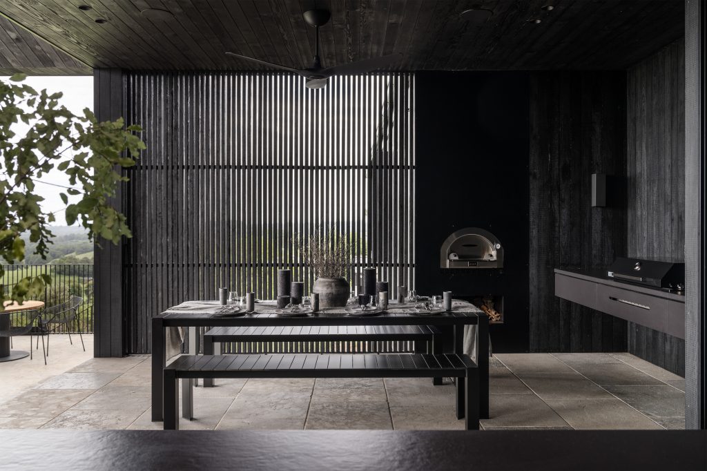 Nox Byron Bay covered entertaining zone with black furniture, bbq and pizza oven