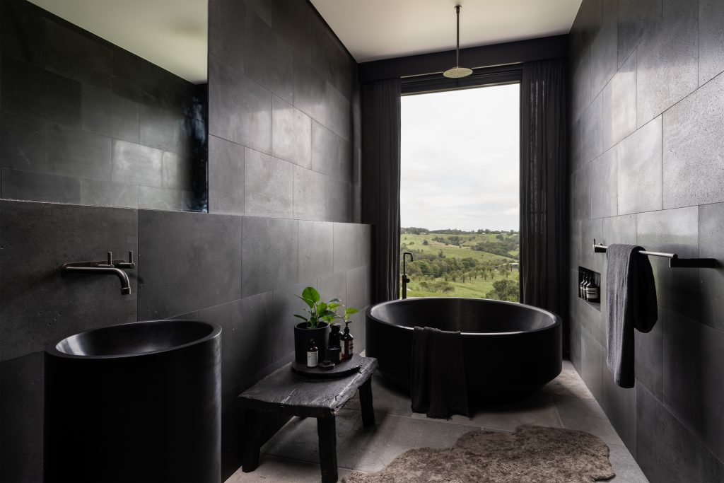 Nox Byron Bay black bathroom with round black bath looking to views