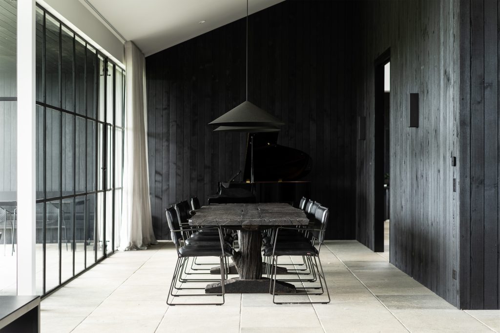 Nox Byron Bay dining room with stone floor tiles, black dining setting and black pendants